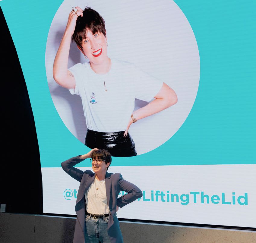 Lauren Mahon stands in front of a picture of herself on a big screen.